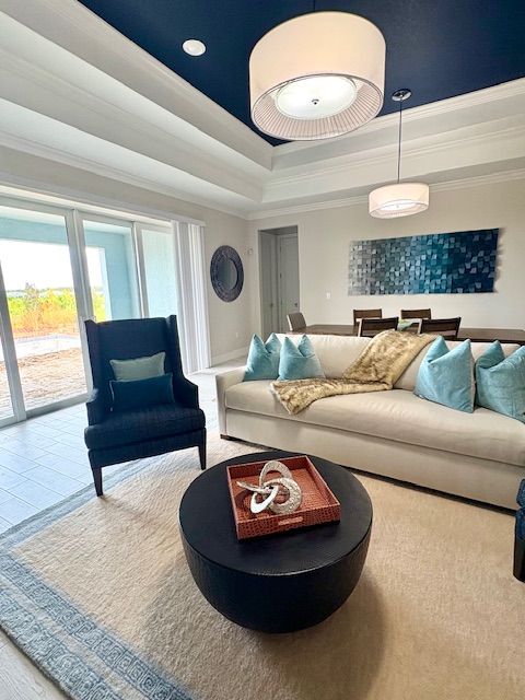 Living room with a sofa, armchair, coffee table, and sliding glass doors leading outside.