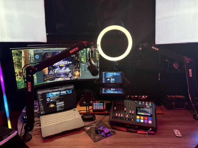 Studio setup with microphones, ring light, monitors, and audio equipment on a desk.