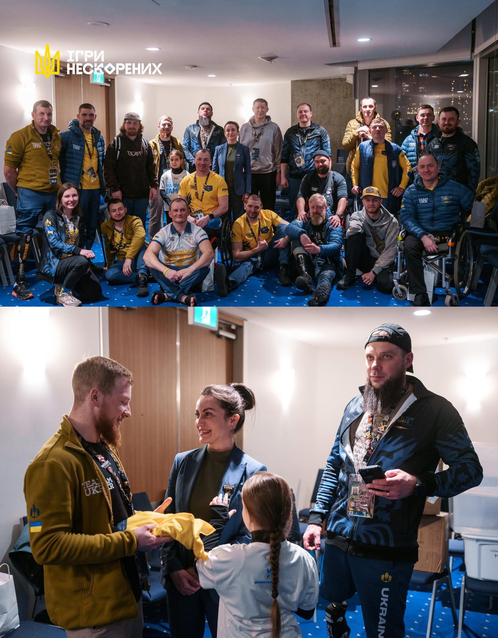 Group of people posing indoors, some wearing yellow jackets, others in casual clothing, with a blue carpet and modern interior.