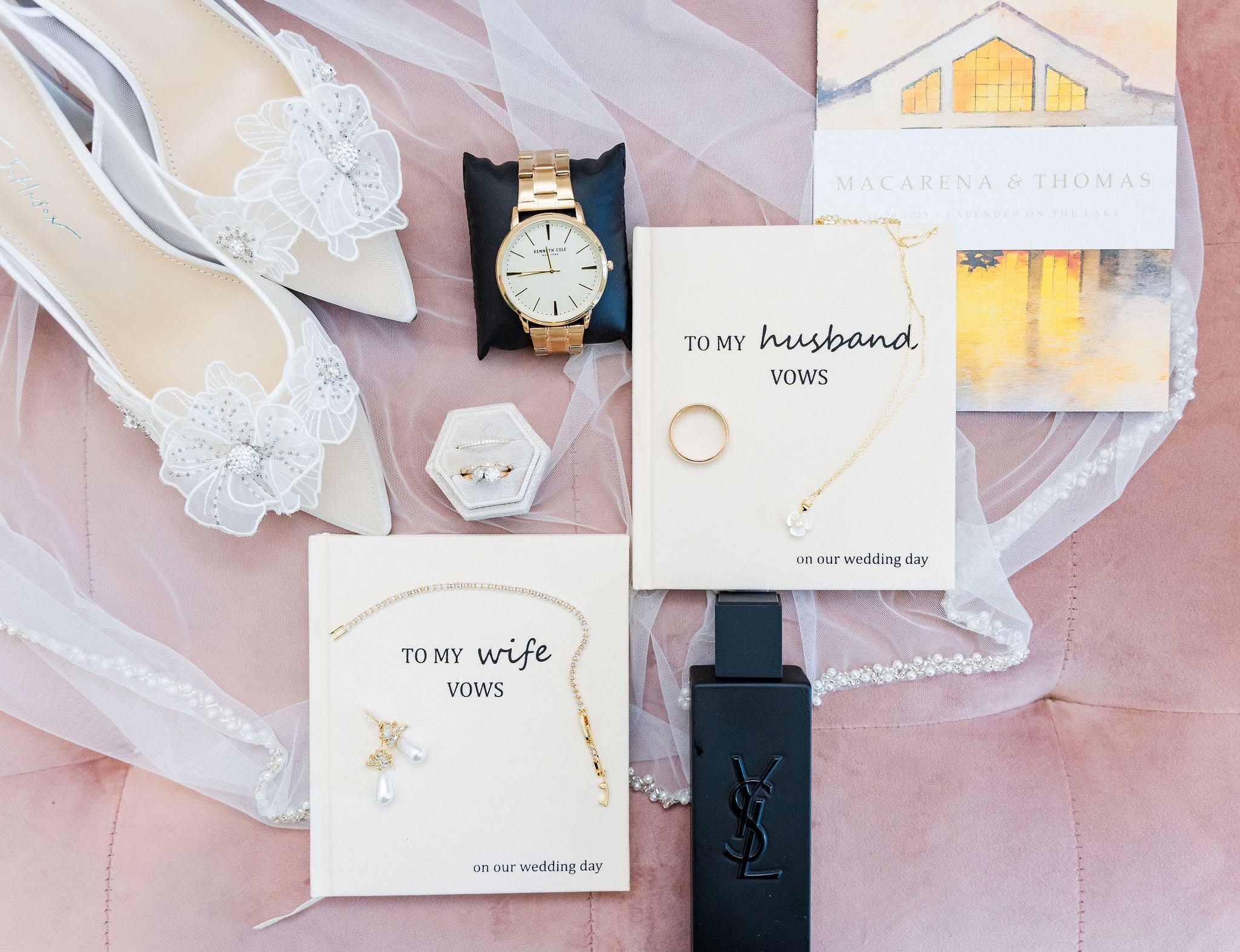 Wedding accessories including shoes, watch, rings, jewelry, and a gift box on pink fabric, with wedding cards. Word count: 20