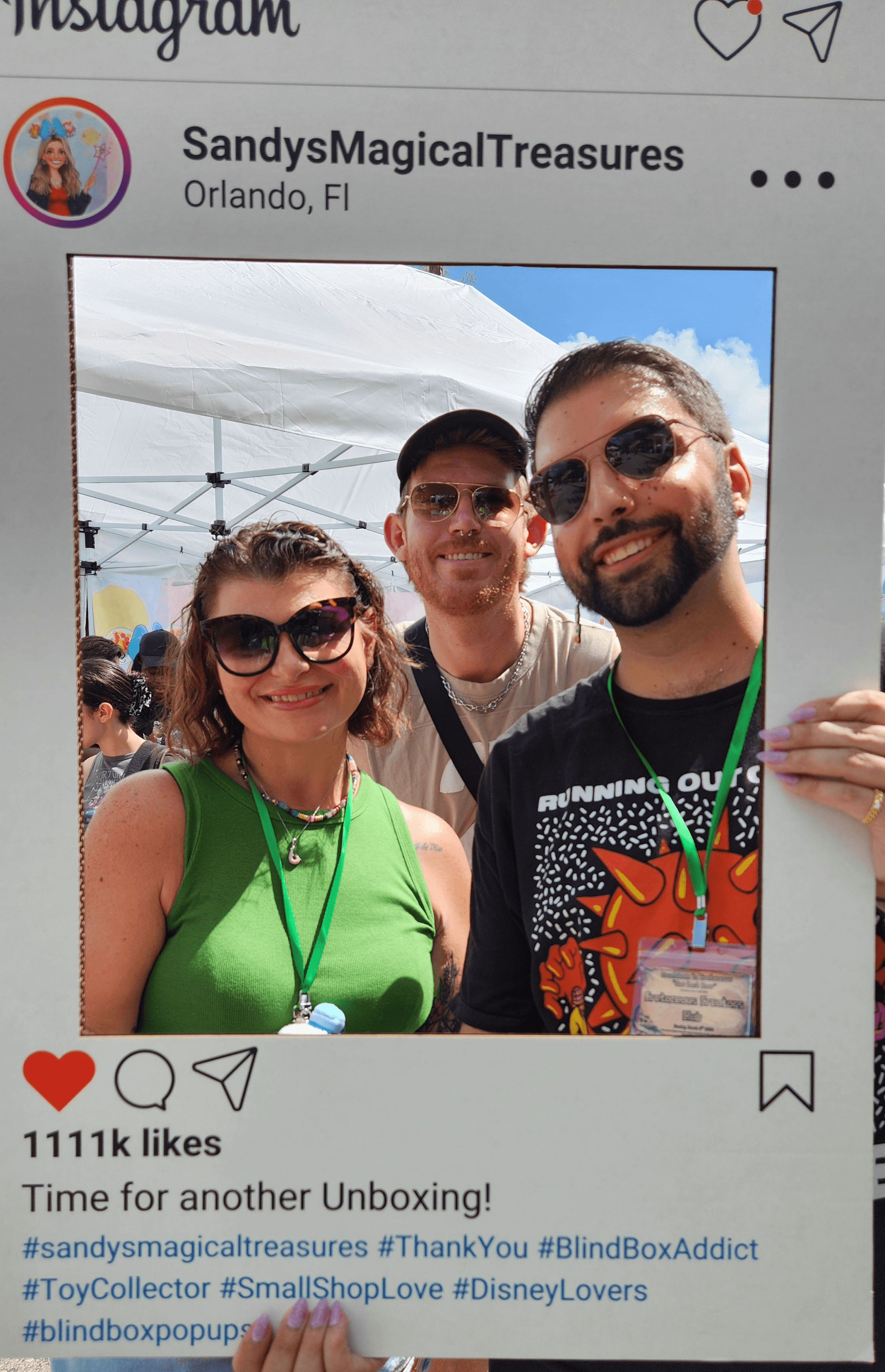Three people smiling outdoors, two women and one man, with tents and a blue sky in the background.