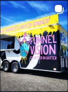 Colorful bus with cartoon dragon and text, parked outdoors under a blue sky.