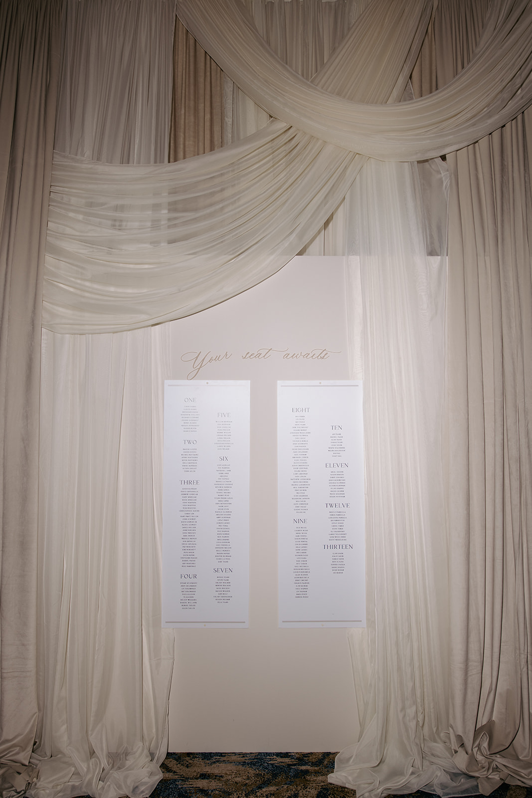 Curtains and drapes with a white board or poster in the center, with text, on a wooden wall background.