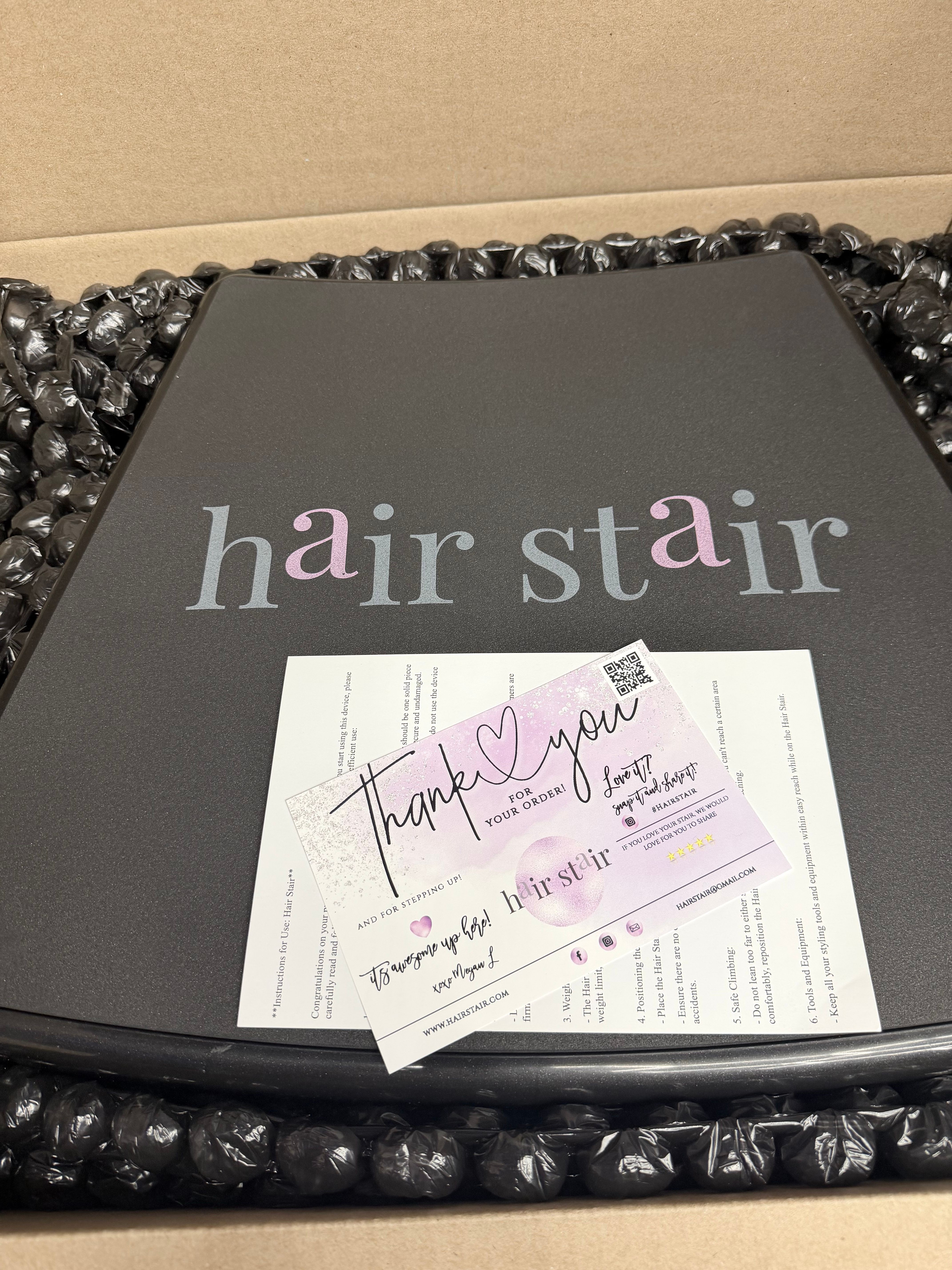 Black box with pink and white text reading 'hair stain' and a check with handwritten notes and a receipt on top.