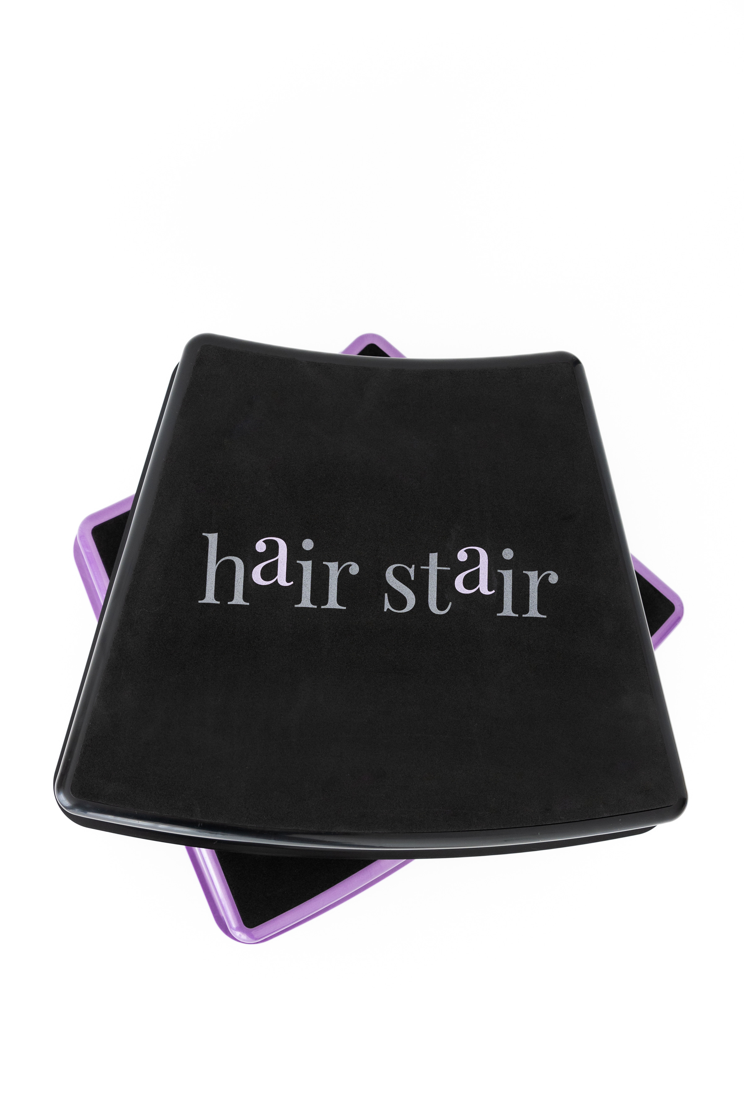 Black compact with purple edges and the words 'hair stain' on the lid, viewed from above.
