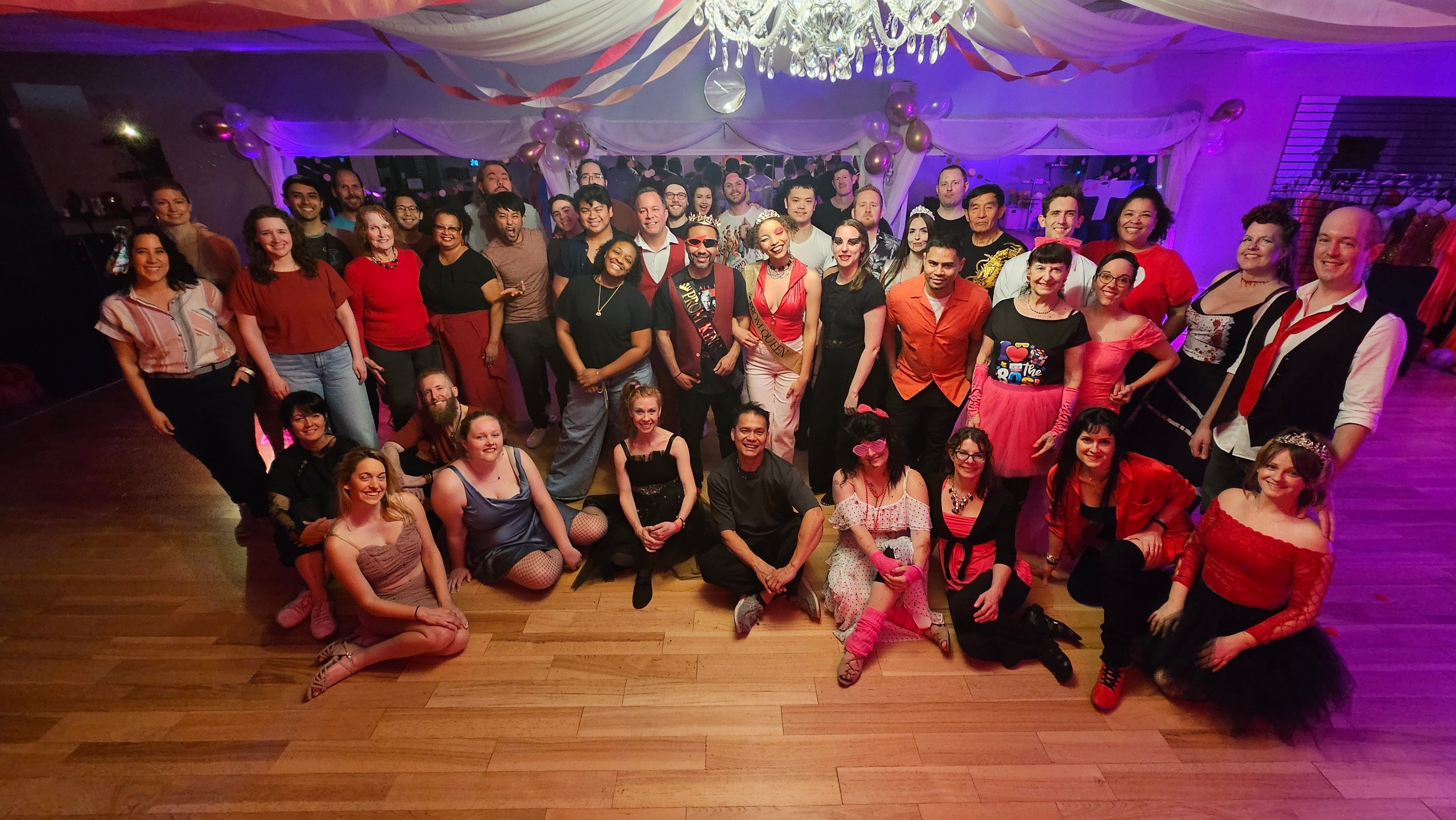 Group of people gathered in a decorated room, posing for a photo at a celebration or party.