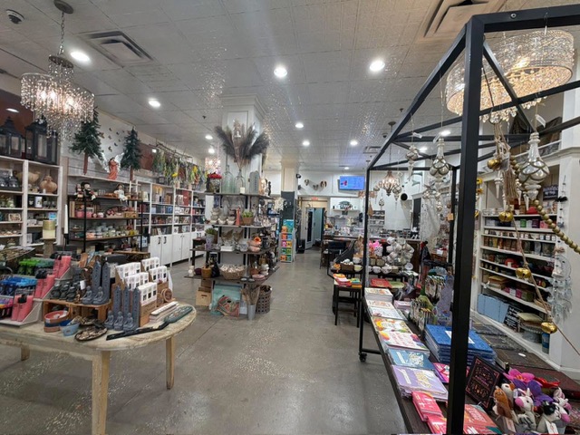 Interior of a store with shelves, tables, and displays filled with various products, including decorations and gifts.
